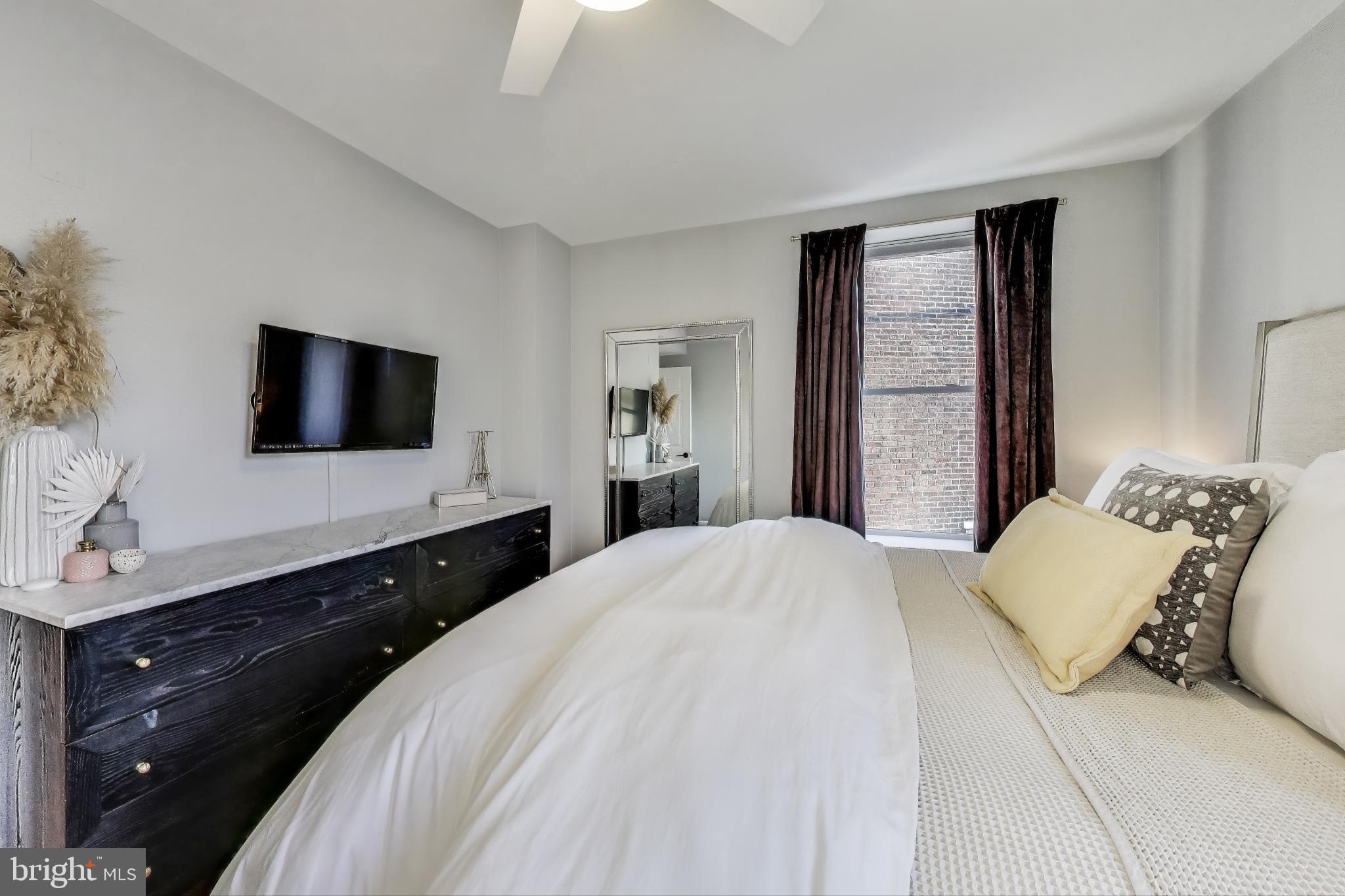52 Quincy Place Northwest, Unit 304 Washington, DC 20001 - Photo 9 of 22 a bedroom with a bed and a flat screen tv