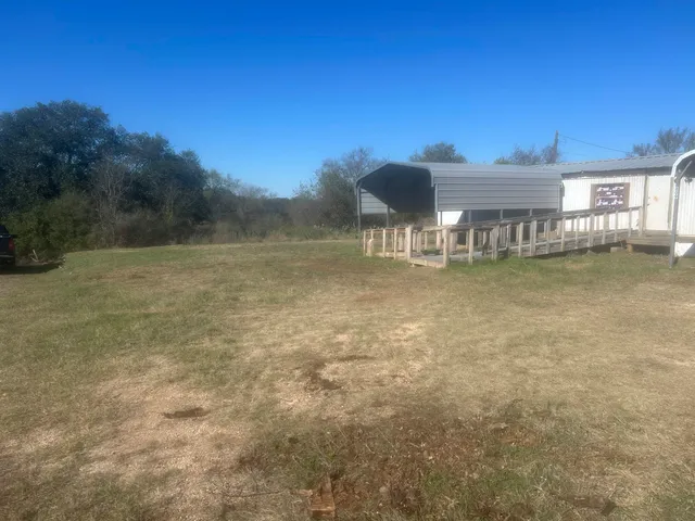 a view of a house with a yard from a lake view