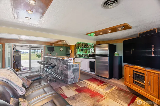a living room with patio furniture and a fireplace
