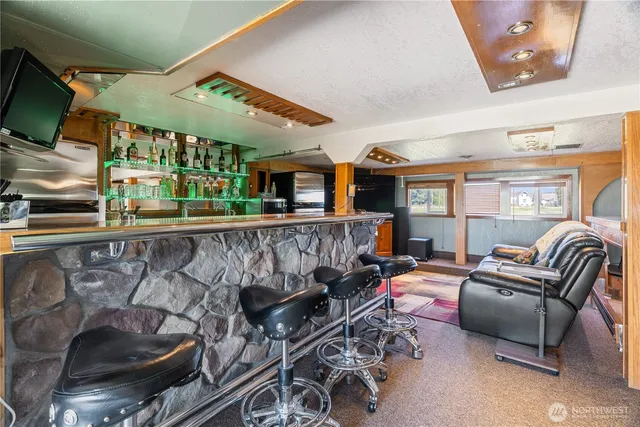 a living room with furniture a flat screen tv and a floor to ceiling window