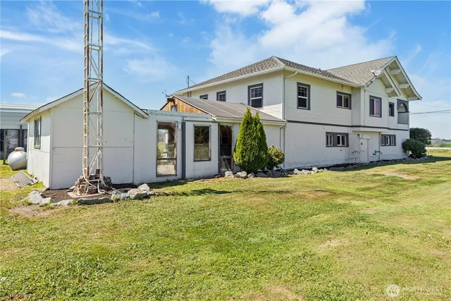 a view of a house with floor to ceiling windows and yard