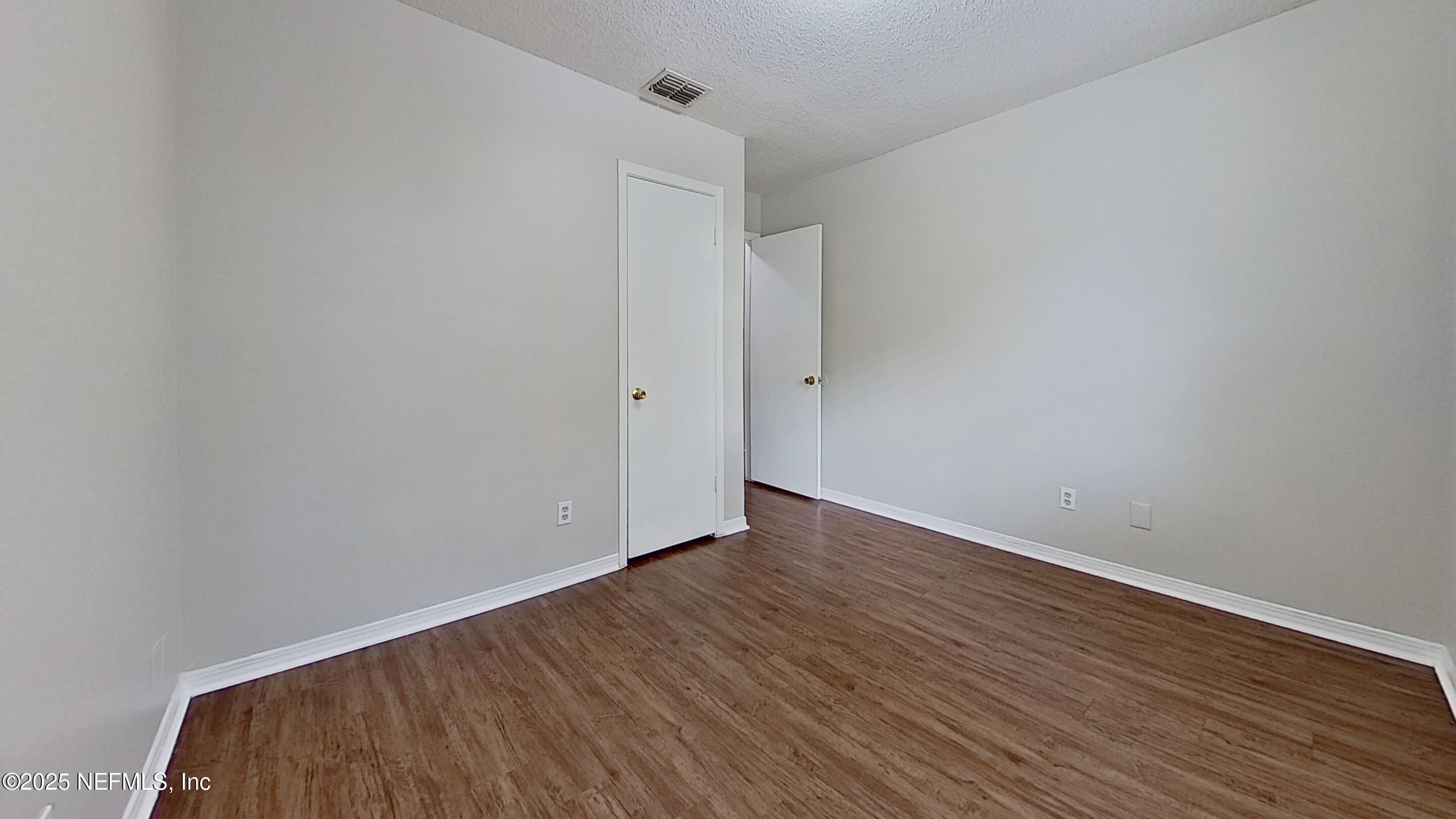 477 Crabapple Court, Unit C Orange Park, FL 32073 - Photo 6 of 13 a view of an empty room with wooden floor