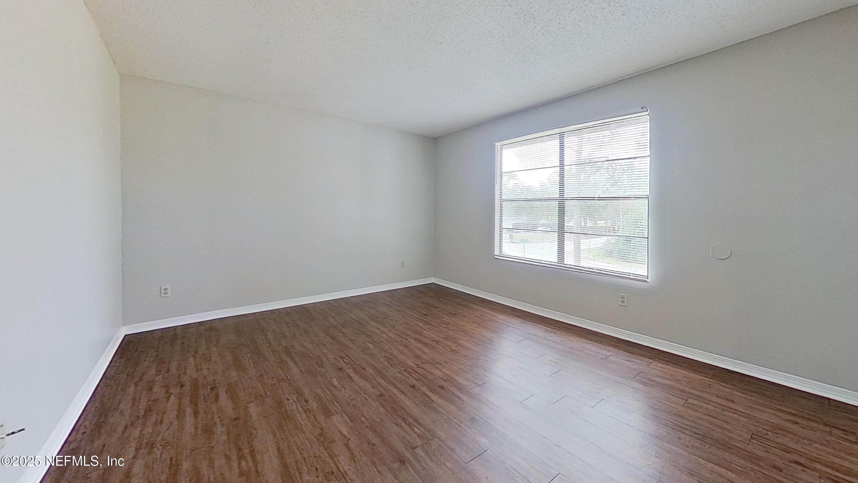 477 Crabapple Court, Unit C Orange Park, FL 32073 - Photo 8 of 13 an empty room with wooden floor and windows