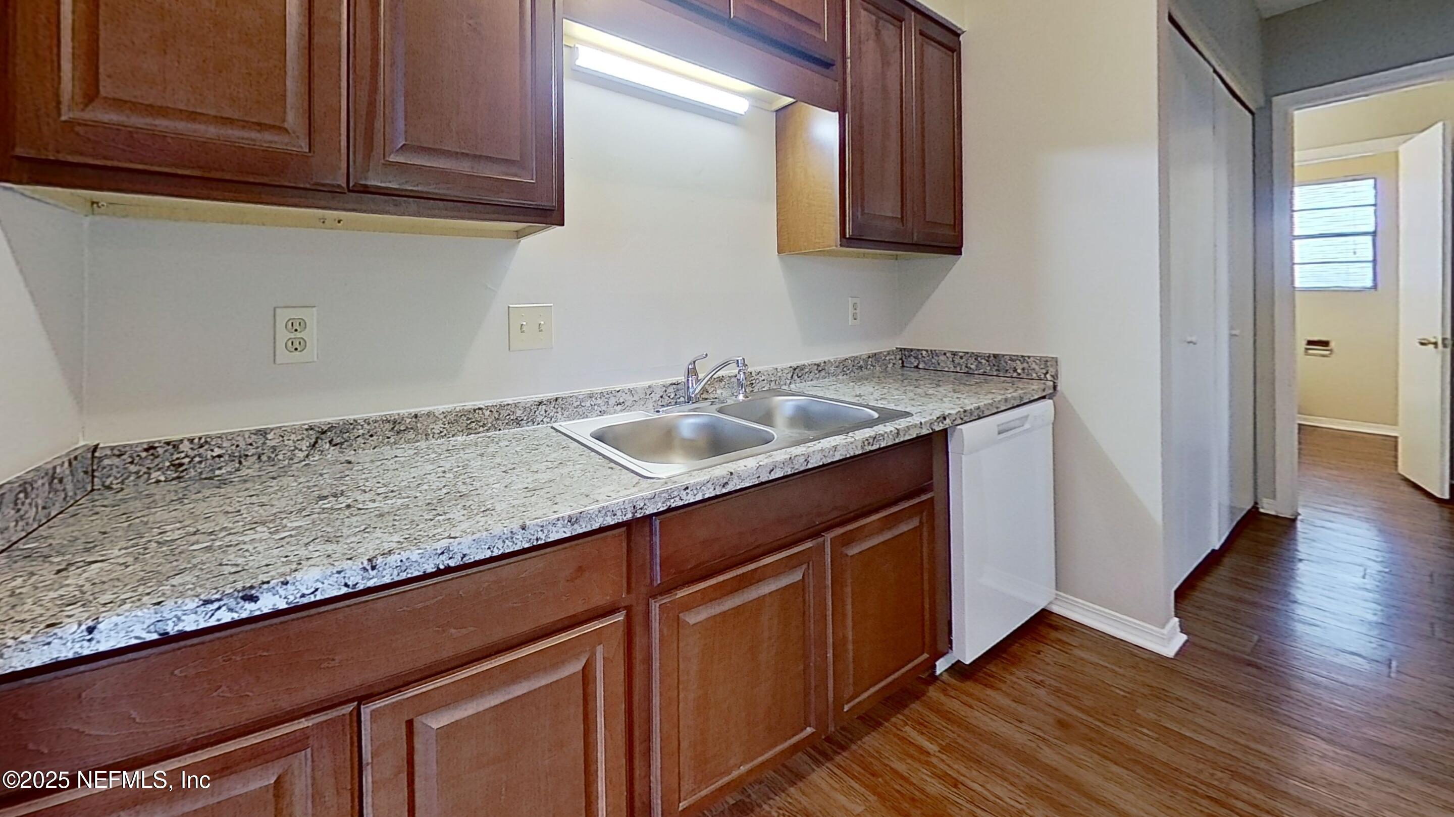 477 Crabapple Court, Unit C Orange Park, FL 32073 - Photo 10 of 13 a sink with granite countertop cabinets and wooden floor