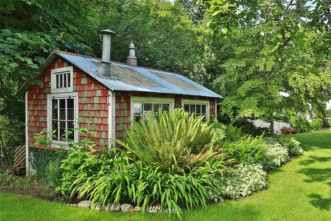 1618 & 1616 Lancaster Road Freeland, WA 98249 - Photo 30 of 40 a front view of a house with a garden