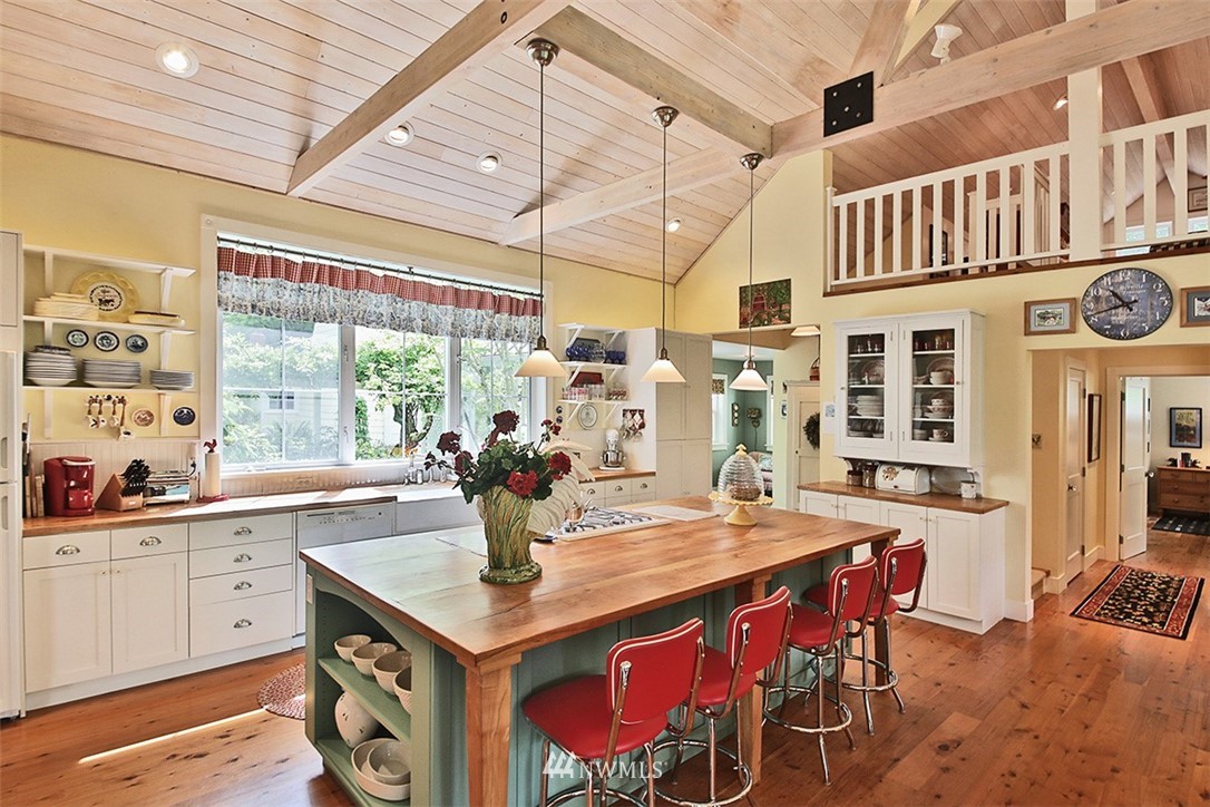 1618 & 1616 Lancaster Road Freeland, WA 98249 - Photo 6 of 40 a open kitchen with stainless steel appliances granite countertop a dining table and chairs with wooden floor