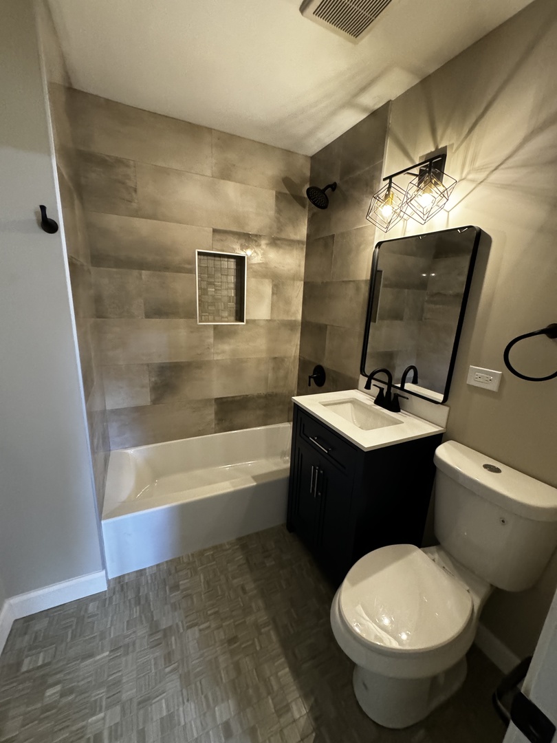 3302 St James Street Rolling Meadows, IL 60008 - Photo 11 of 20 a bathroom with a toilet sink and mirror