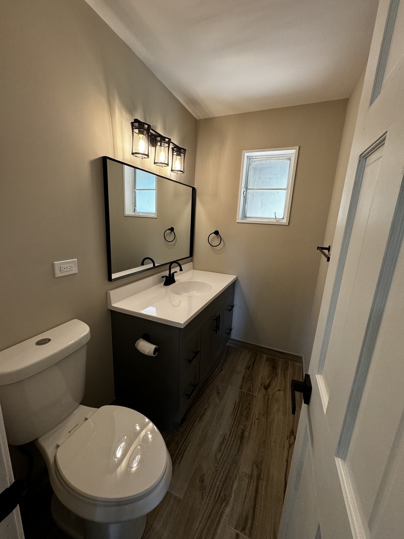 3302 St James Street Rolling Meadows, IL 60008 - Photo 13 of 20 a bathroom with a toilet sink and mirror