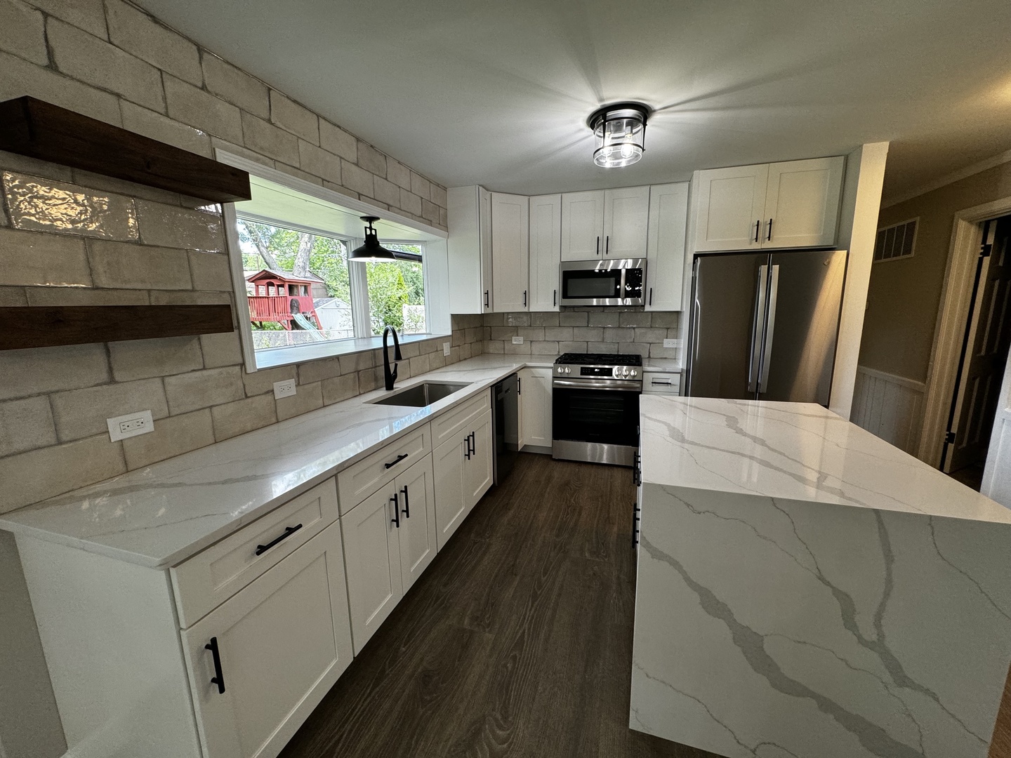 3302 St James Street Rolling Meadows, IL 60008 - Photo 17 of 20 a large kitchen with stainless steel appliances kitchen island granite countertop a sink and cabinets