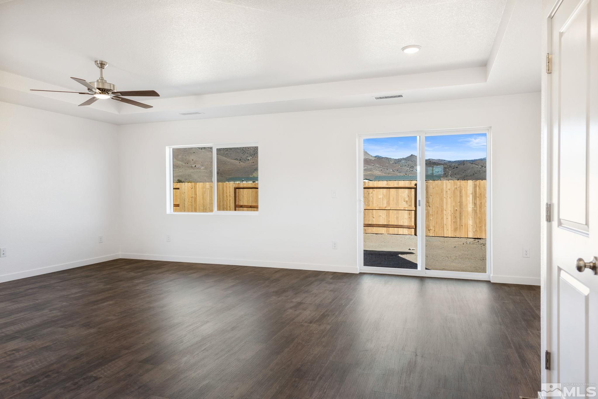 211 Green Lane Dayton, NV 89403 - Photo 16 of 28 an empty room with wooden floor chandelier fan and windows