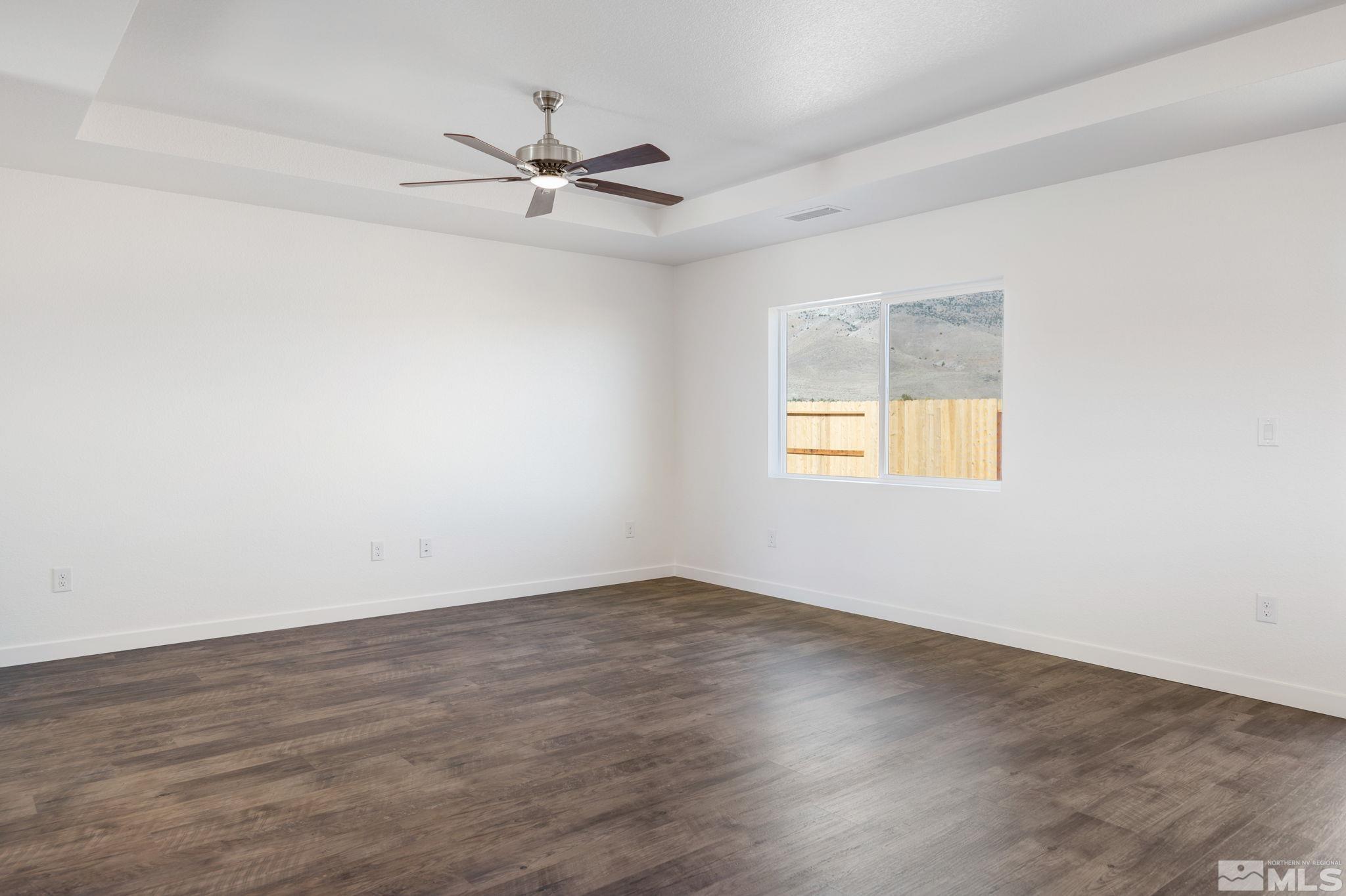 211 Green Lane Dayton, NV 89403 - Photo 10 of 28 an empty room with wooden floor fan and windows