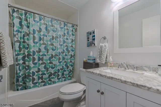a bathroom with a granite countertop sink a toilet and a mirror