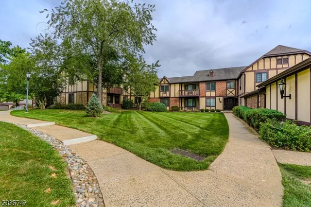 a view of a big building with a big yard and large trees
