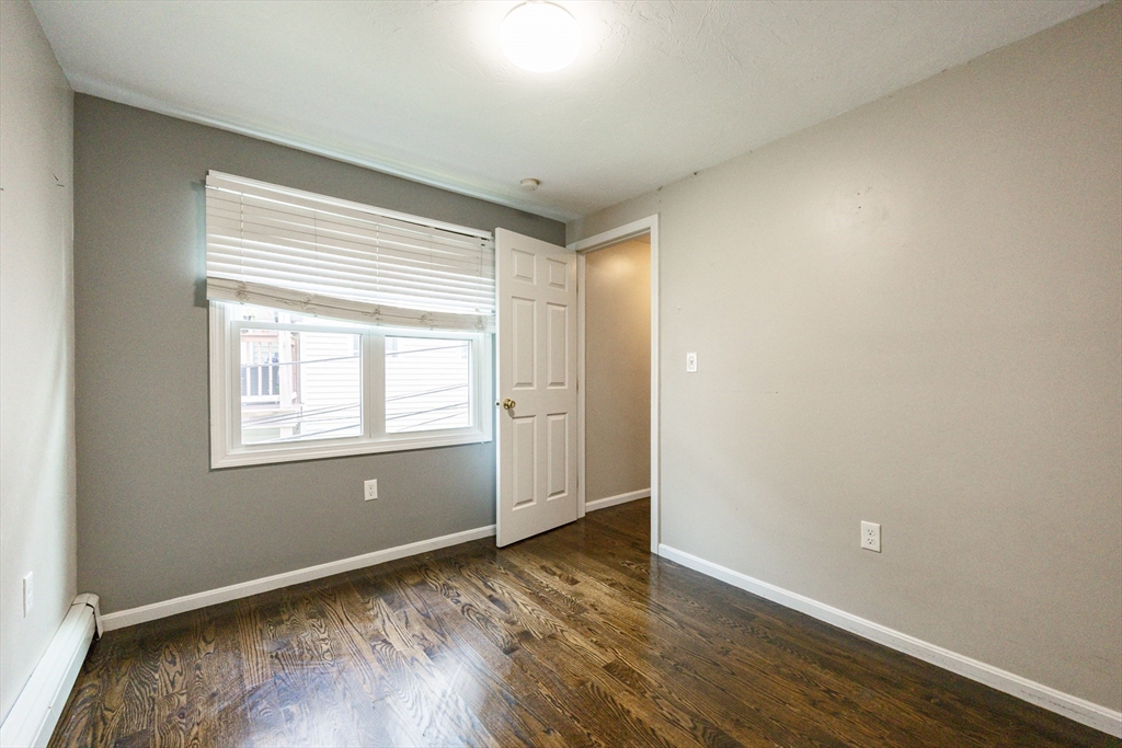 210 West Sixth Street, Unit 210 Boston, MA 02127 - Photo 25 of 36 an empty room with wooden floor and windows