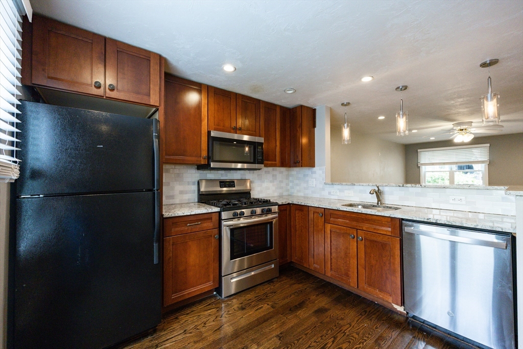 210 West Sixth Street, Unit 210 Boston, MA 02127 - Photo 6 of 36 a kitchen with granite countertop stainless steel appliances and wooden cabinets