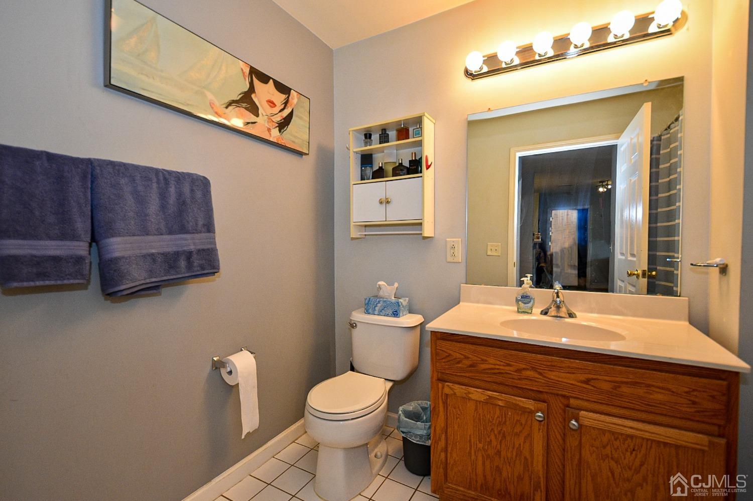 358 Rector Street, Unit 508 Perth Amboy, NJ 08861 - Photo 6 of 30 a bathroom with a toilet a sink and mirror