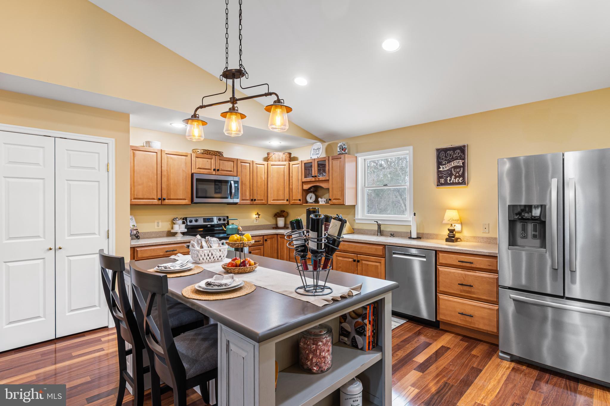 4507 Babylon Road Westminster, MD 21158 - Photo 11 of 63 a kitchen with a refrigerator a stove a sink dishwasher a dining table and chairs with wooden floor