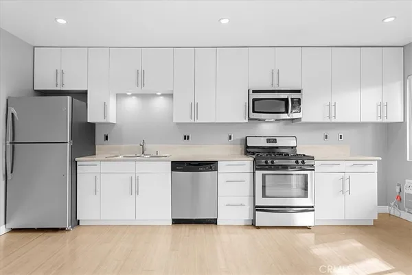 a kitchen with granite countertop white cabinets and stainless steel appliances