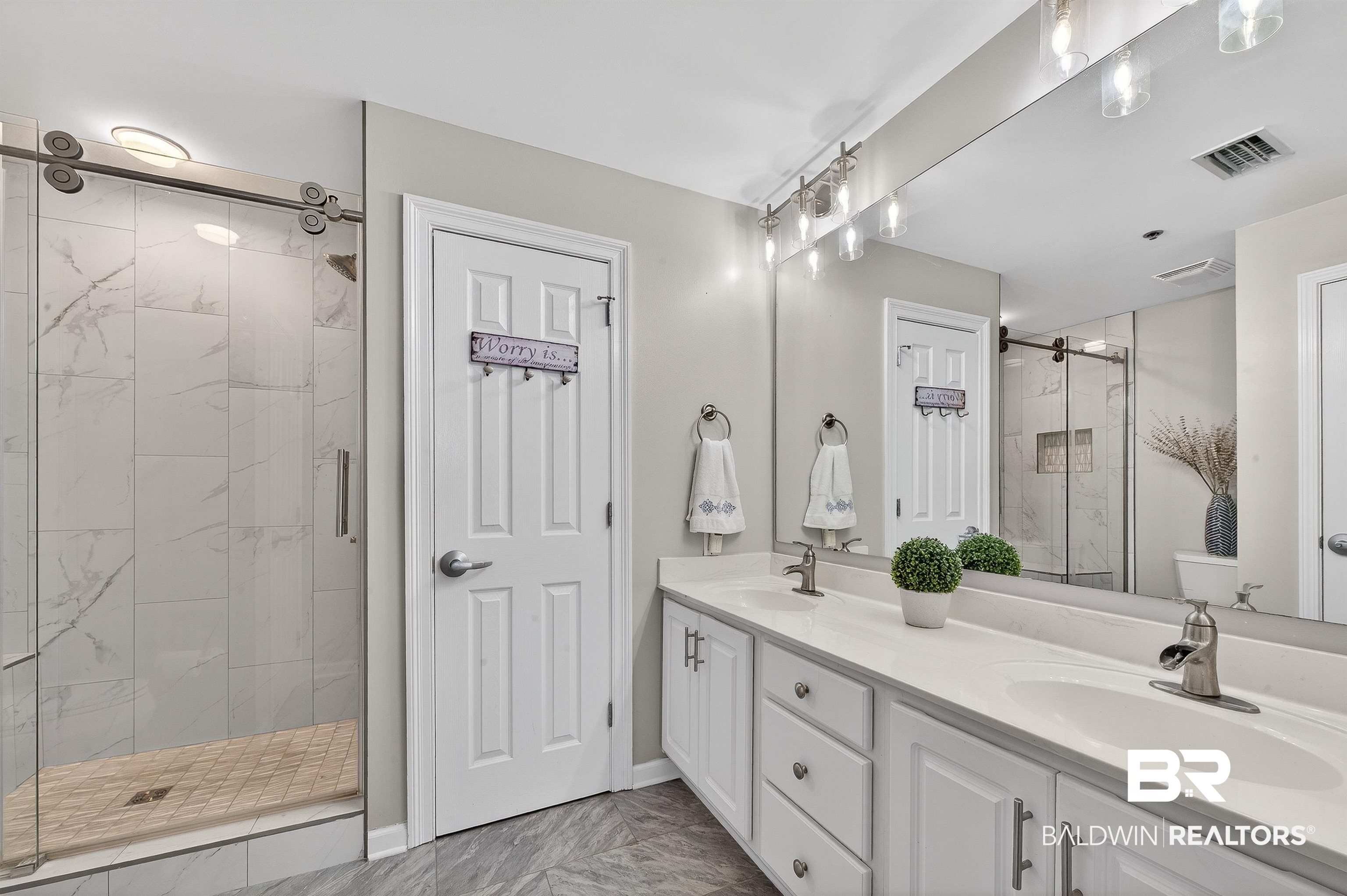 27282 Canal Road, Unit 408 Orange Beach, AL 36561 - Photo 11 of 37 Bathroom with a marble finish shower, double vanity, and light marble finish floors