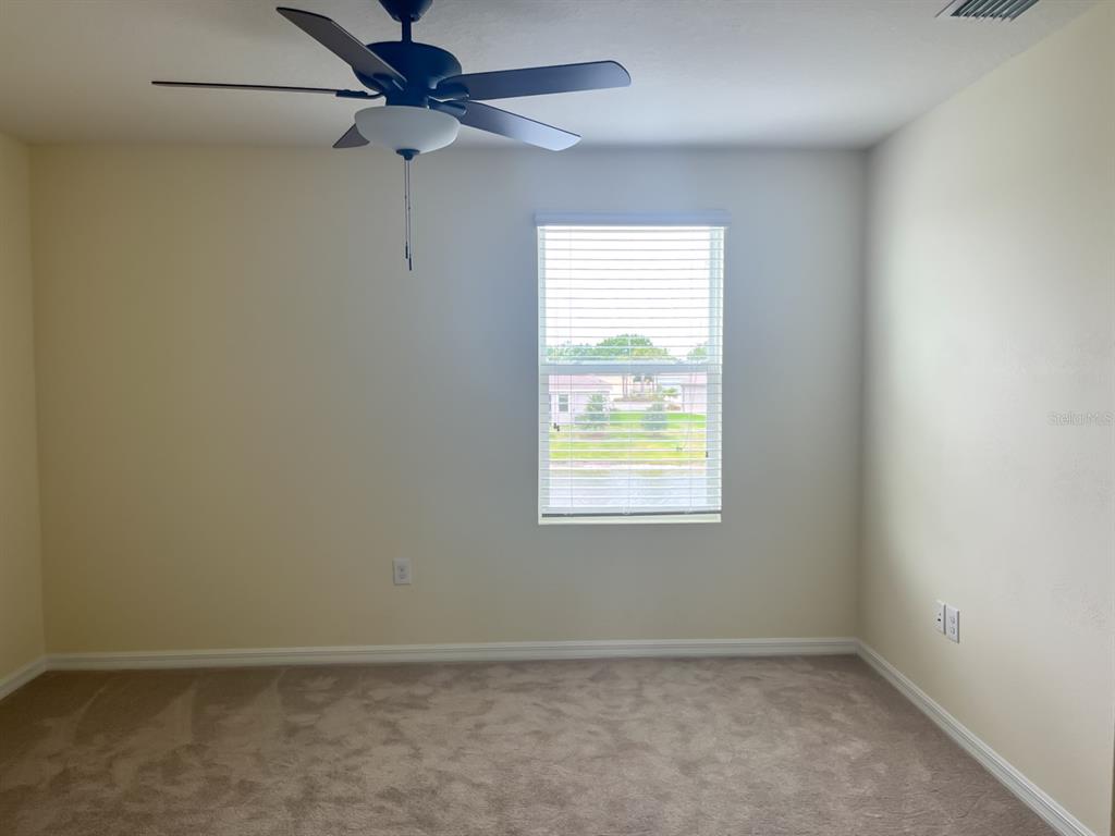 7690 Tuscan Bay Circle Wesley Chapel, FL 33545 - Photo 11 of 14 an empty room with a window and a fan