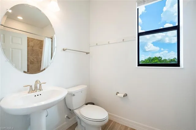 a bathroom with a toilet a sink and mirror
