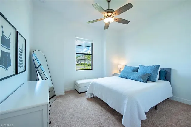a bedroom with a bed chandelier and a window