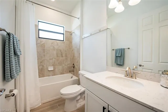 a bathroom with a toilet a sink a mirror a bathtub and shower