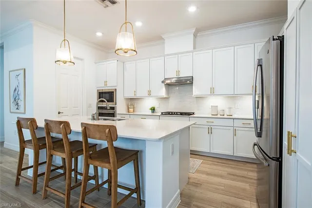 a kitchen with a dining table chairs sink and cabinets