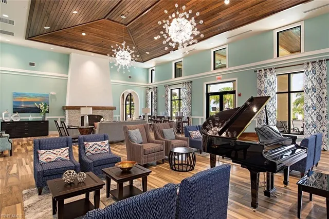 a living room with furniture a chandelier and a piano