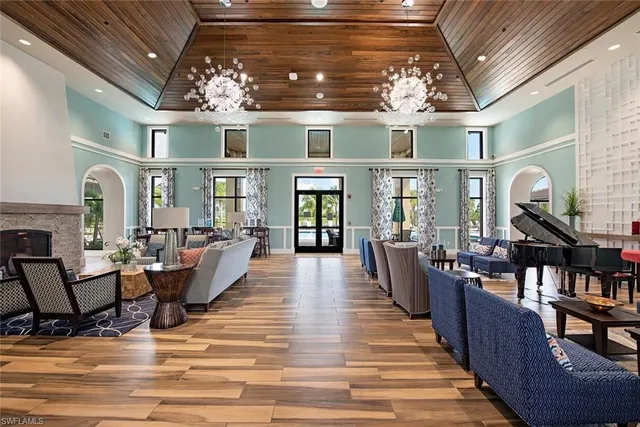 a dining hall with couches a flat tv screen and couches with wooden floor