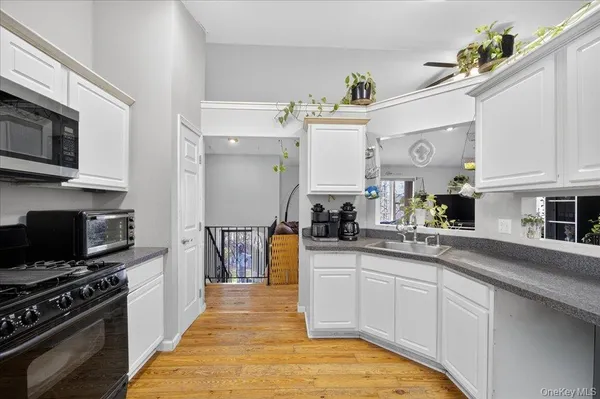 a kitchen with stainless steel appliances granite countertop a stove top oven a sink a counter space and cabinets