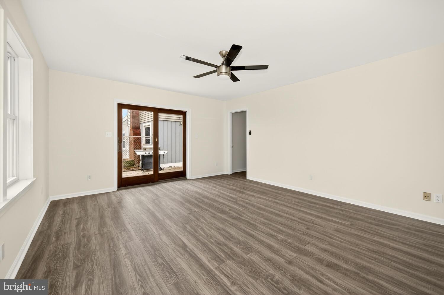 6746 Quaker Neck Road Chestertown, MD 21620 - Photo 41 of 50 an empty room with wooden floor a ceiling fan and windows