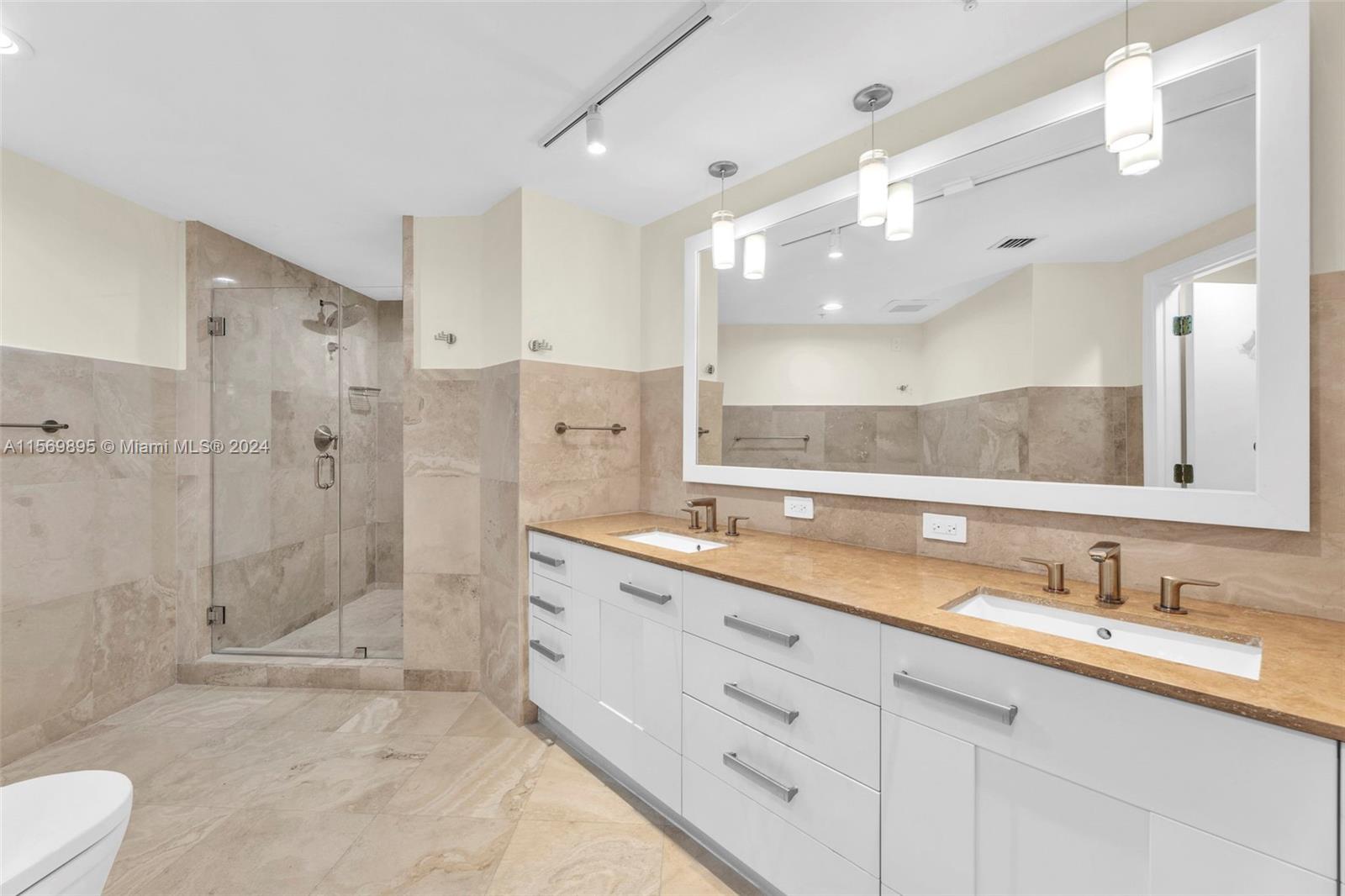 3540 Main Highway, Unit 310 Miami, FL 33133 - Photo 17 of 47 a bathroom with a granite countertop sink mirror and shower