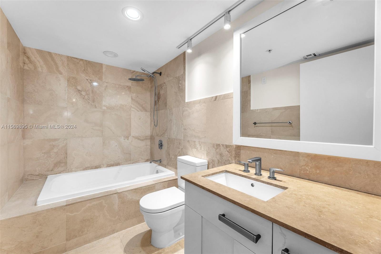 3540 Main Highway, Unit 310 Miami, FL 33133 - Photo 22 of 47 a bathroom with a granite countertop sink a toilet and bathtub