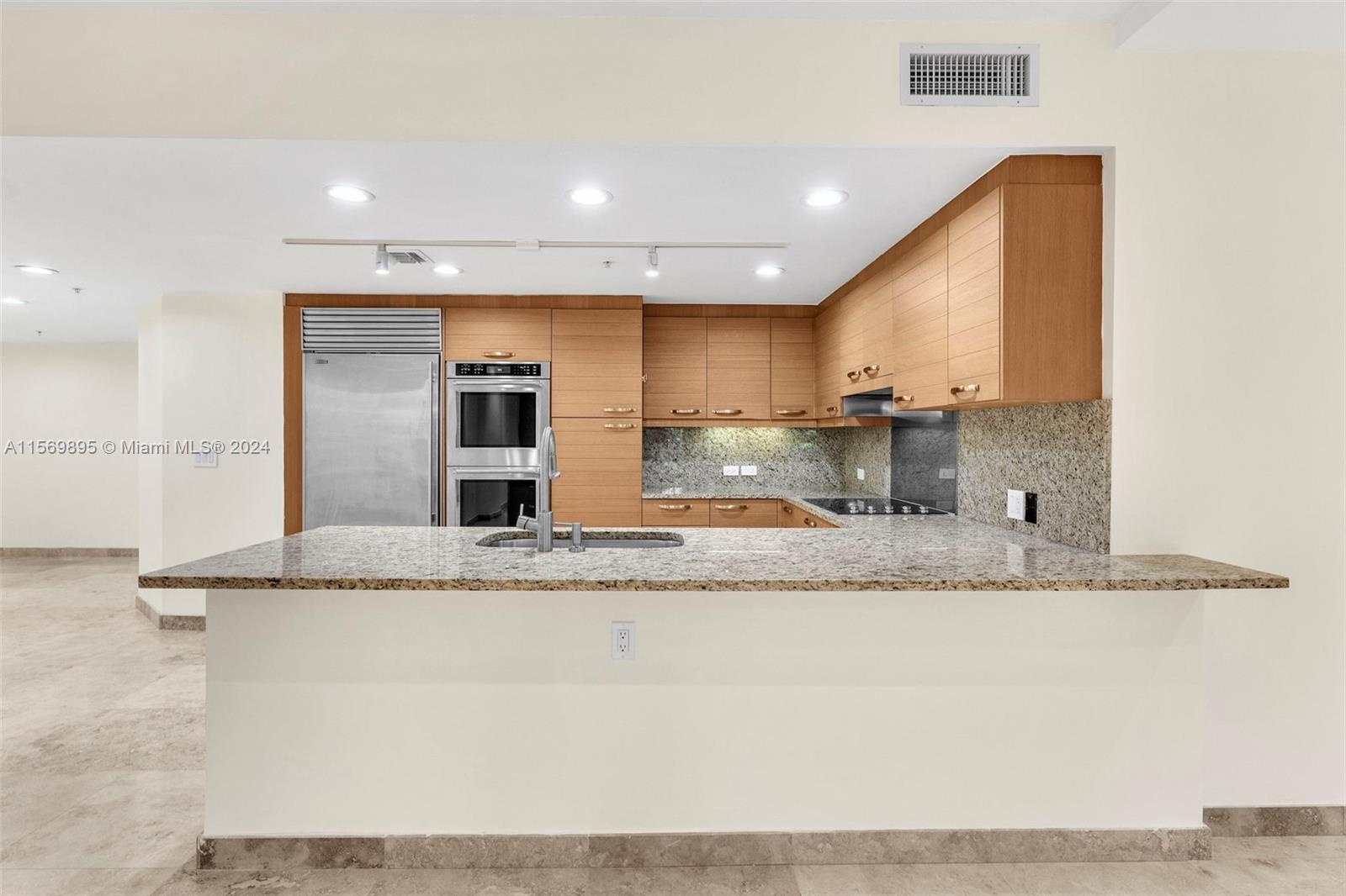 3540 Main Highway, Unit 310 Miami, FL 33133 - Photo 8 of 47 a large kitchen with granite countertop a sink and a stove