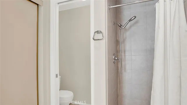 a view of an empty room with wooden floor and closet