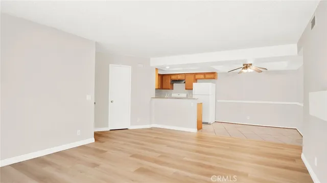 an empty room with wooden floor and cabinet