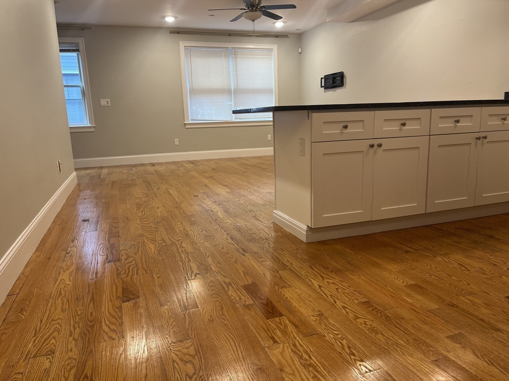 45 Spring Street, Unit 18 Boston, MA 02132 - Photo 3 of 29 en empty room with wooden floor