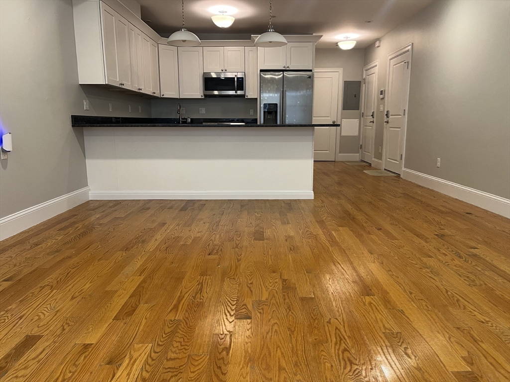 45 Spring Street, Unit 18 Boston, MA 02132 - Photo 5 of 29 a kitchen with stainless steel appliances a refrigerator sink and microwave