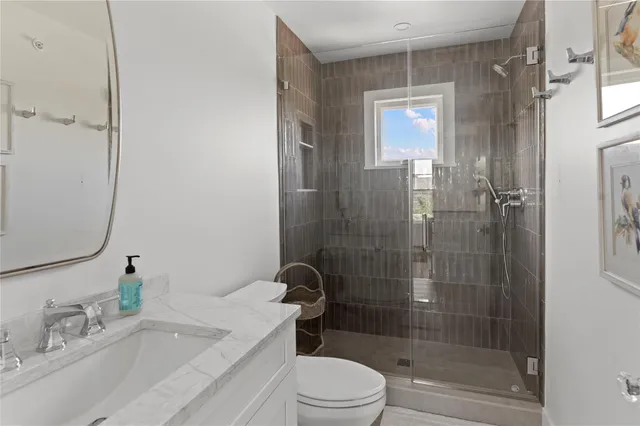 a bathroom with a bathtub shower sink mirror and toilet