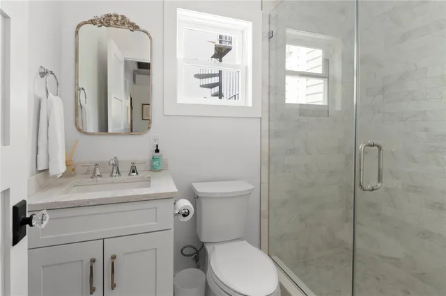 a bathroom with a toilet sink vanity and mirror