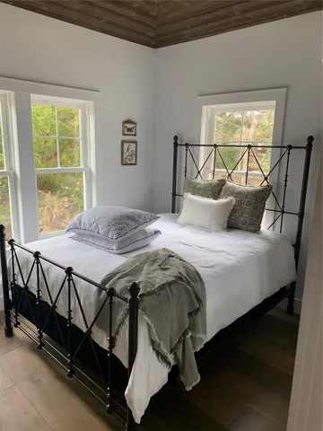 a bedroom with a bed a window and outside view