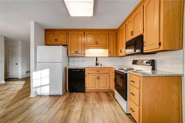 a kitchen with a sink a counter top space stainless steel appliances and cabinets