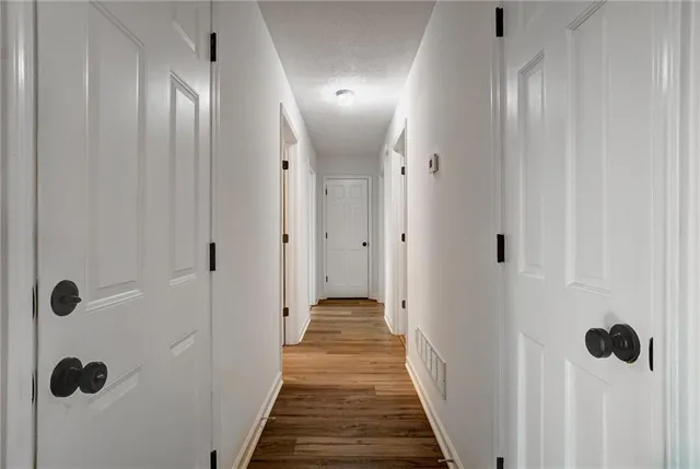a view of a hallway with wooden floor