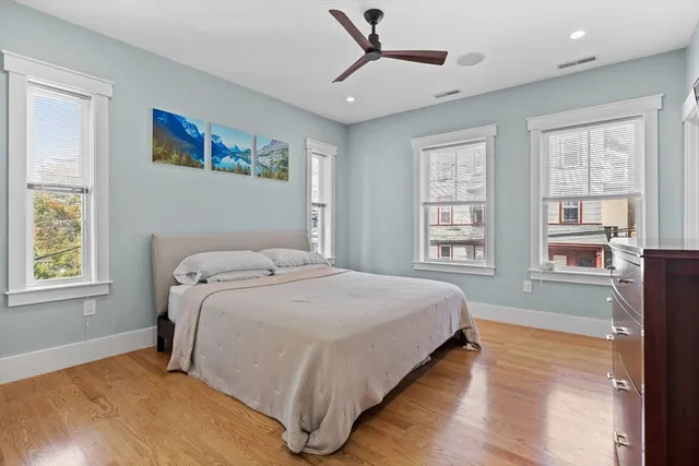 a spacious bedroom with a bed and a flat screen tv