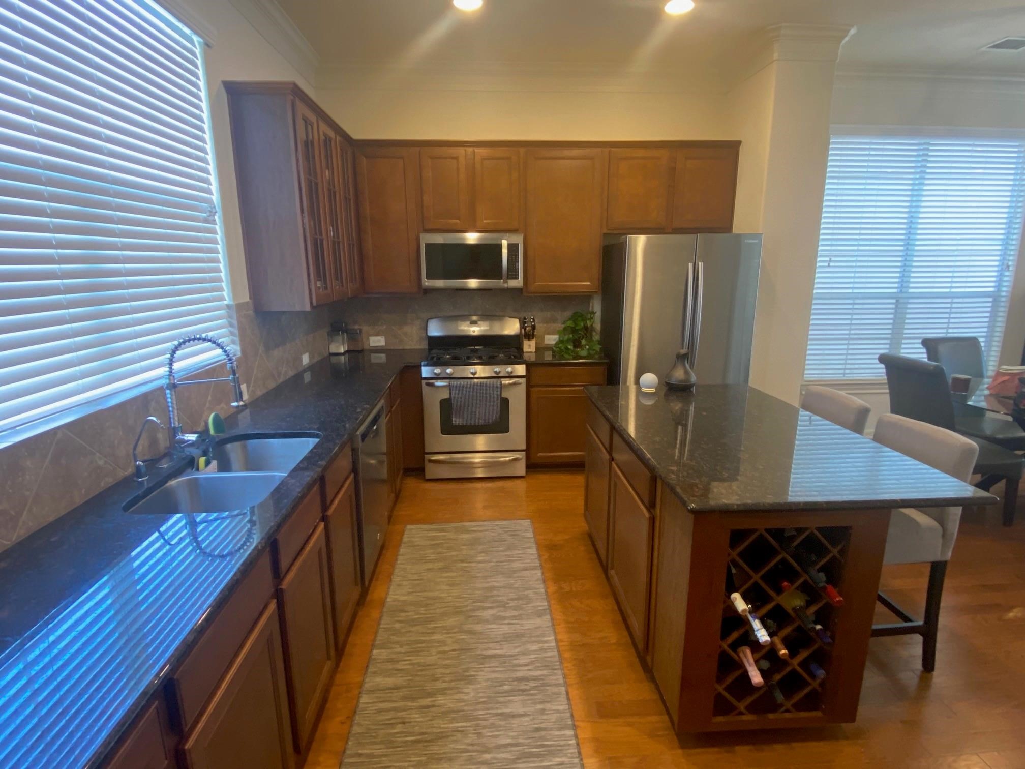 3209 Clearview Circle Houston, TX 77025 - Photo 5 of 13 a kitchen with stainless steel appliances granite countertop a sink wooden cabinets and a granite counter tops