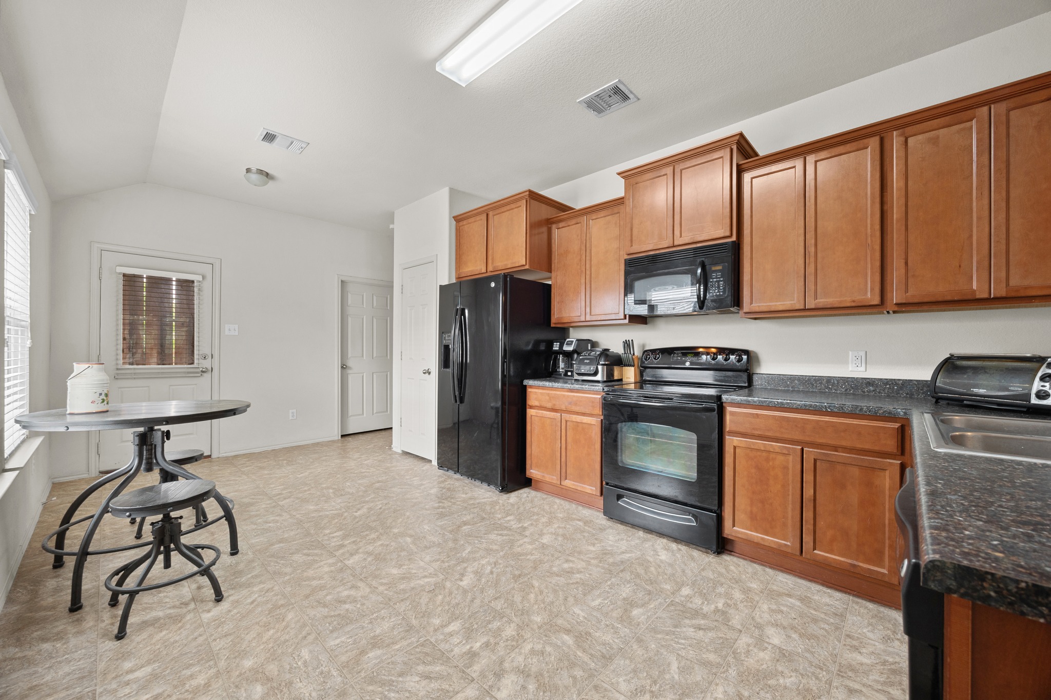 621 Amber Lane Jarrell, TX 76537 - Photo 8 of 22 a kitchen with stainless steel appliances granite countertop a stove refrigerator sink and cabinets