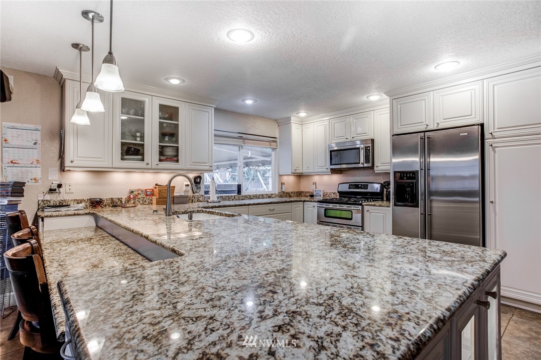 2510 166th Place Southeast Bothell, WA 98012 - Photo 3 of 24 a kitchen with stainless steel appliances granite countertop a sink refrigerator and microwave