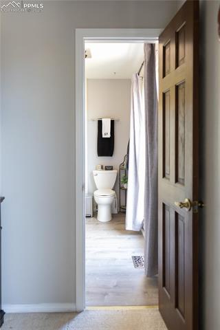 8115 Mustang Road Colorado Springs, CO 80908 - Photo 29 of 48 Bathroom featuring a shower with shower curtain and light wood-style floors