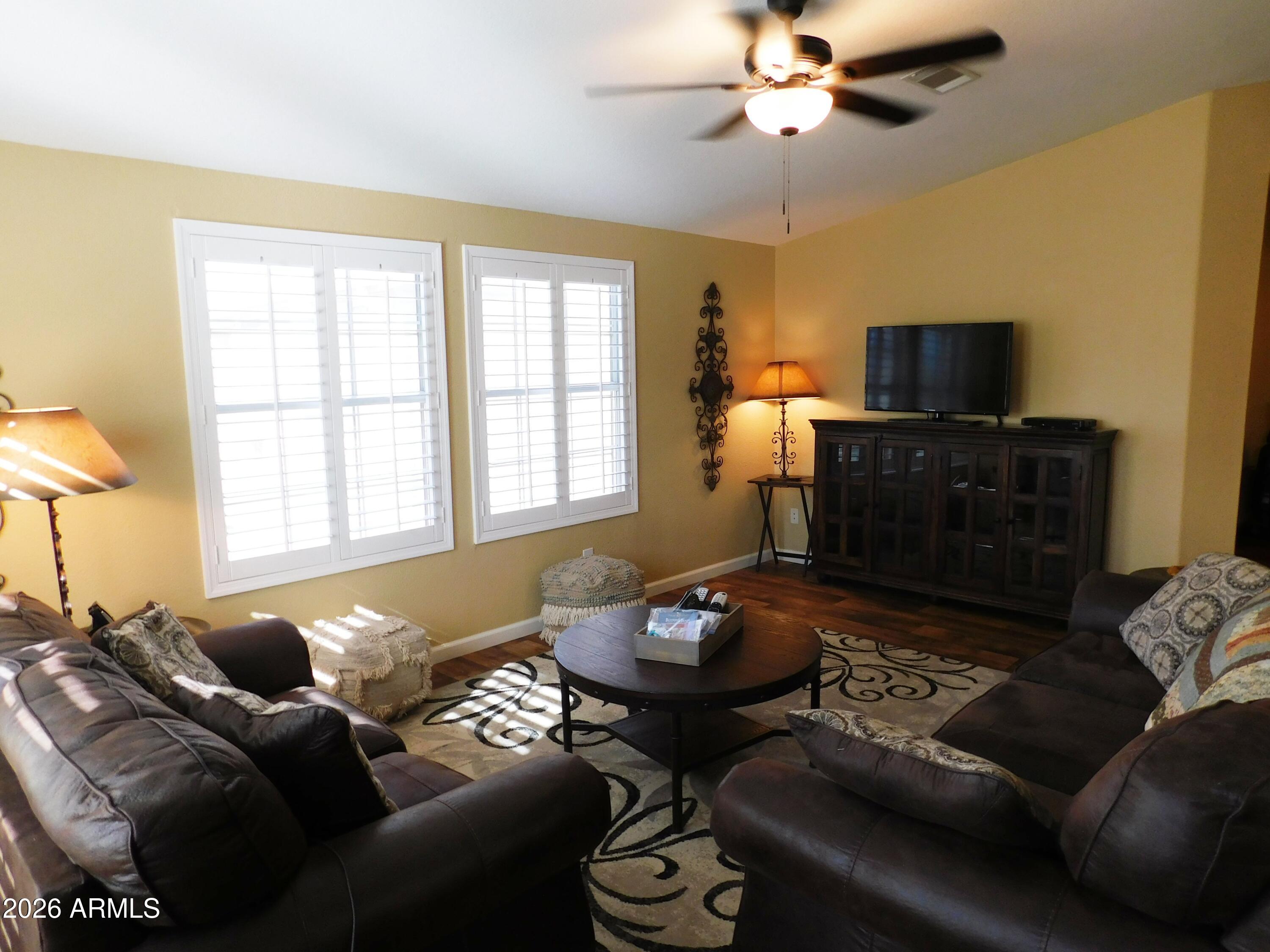3301 South Goldfield Road, Unit 1054 Apache Junction, AZ 85119 - Photo 12 of 41 a living room with furniture and a flat screen tv